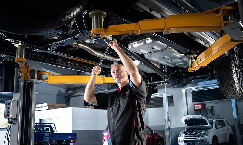 Mechanic looking at the bottom of a car